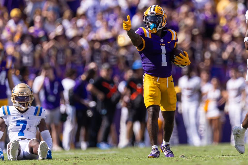 Sep 21, 2024; Baton Rouge, Louisiana, USA; LSU Tigers wide receiver Aaron Anderson (1) reacts after making a first down against UCLA Bruins defensive back K.J. Wallace (7) during the first half at Tiger Stadium. Mandatory Credit: Stephen Lew-Imagn Images