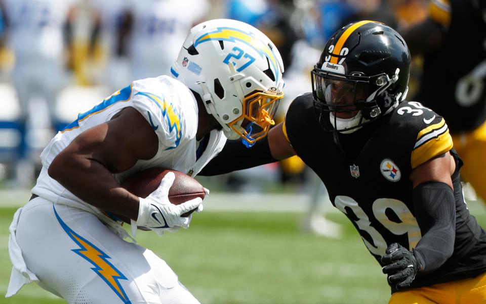 Sep 22, 2024; Pittsburgh, Pennsylvania, USA; Los Angeles Chargers running back J.K. Dobbins (27) runs the ball against Pittsburgh Steelers safety Minkah Fitzpatrick (39) during the first quarter at Acrisure Stadium. Mandatory Credit: Charles LeClaire-Imagn Images