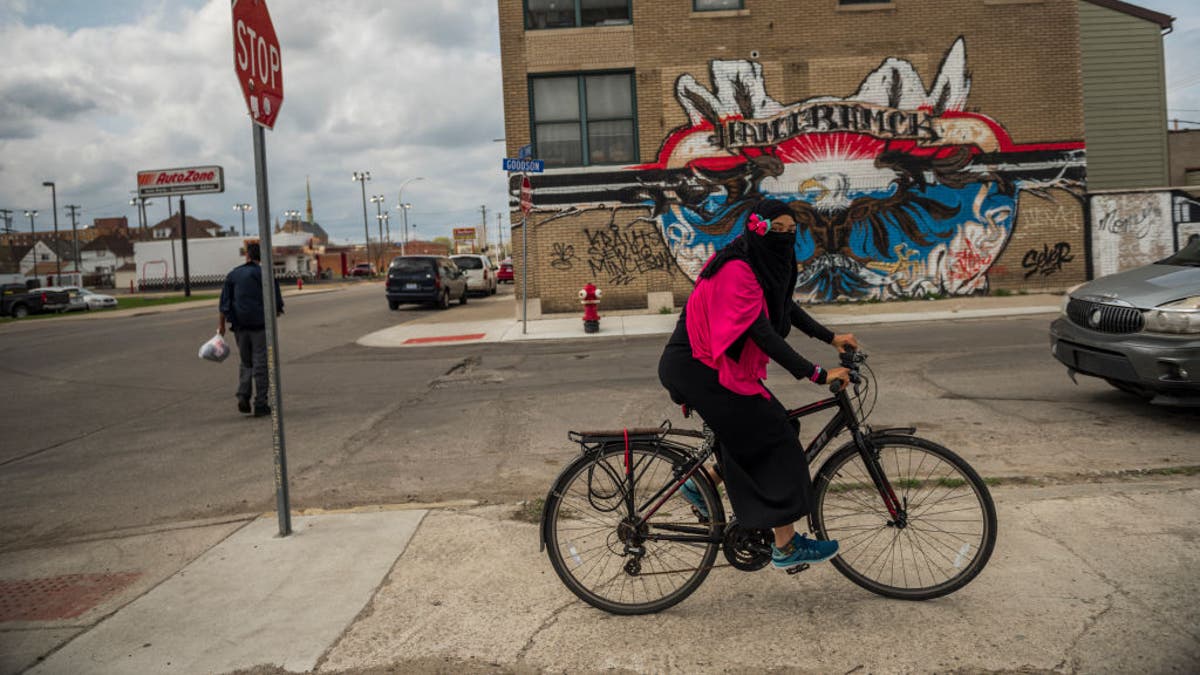 Muslim woman covered up, riding bike in Hamtramck, Mich. in 2017 photo