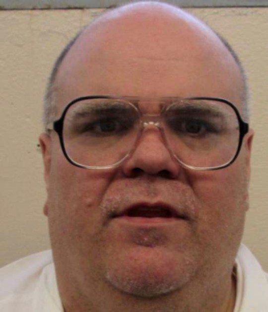 Booking photo of Alan Eugene Miller who was convicted of capital murder in a workplace shooting rampage that killed three men in 1999 shows him wearing glasses and a white T-shirt