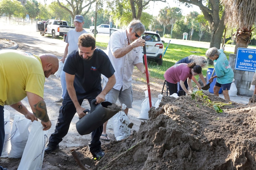 Sandbags are filled at a public site while residents prepare their homes for potential...