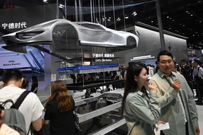 Visitors stand in front of a battery from the Contemporary Amperex Technology Co., Limited (CATL) company is displayed at the Beijing Auto Show on April 25, 2024