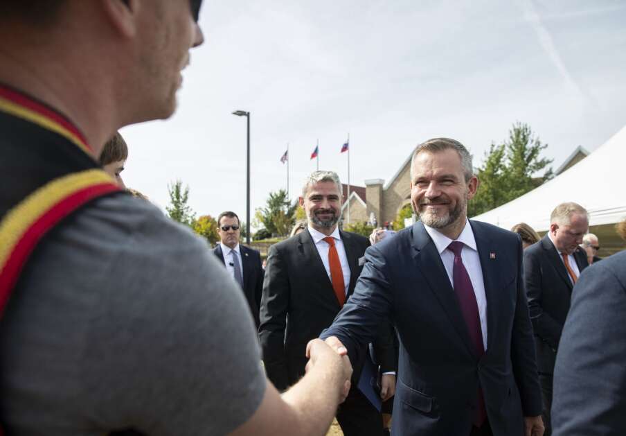 Slovak Republic President Peter Pellegrini shakes hands with a community member during the dedication of the Buresh Immigration Clock Tower in Czech Village in Cedar Rapids on Friday. (Savannah Blake/The Gazette)