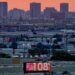 FILE - A sign displays an unofficial temperature as jets taxi at Sky Harbor International Airport at dusk, July 12, 2023, in Phoenix.  Arizona voters are looking to the climate plans of Kamala Harris and Donald Trump amid rising temperatures and other climate change impacts.(AP Photo/Matt York, File)