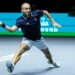 Dan Evans lunges for a forehand in the Davis Cup 2024, wearing a blue shirt and white shorts.