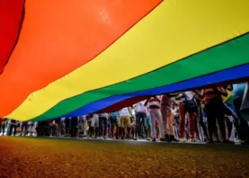 AFP A camera shot taken from beneath a large LGBT rainbow flag shows people's legs standing to the right of the flag