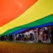 AFP A camera shot taken from beneath a large LGBT rainbow flag shows people's legs standing to the right of the flag