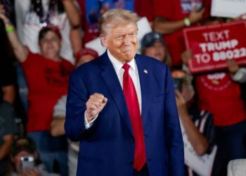 Donald Trump shows off his statement fist at college football showdown in Alabama following dark rhetoric