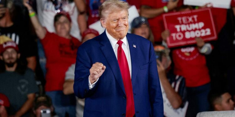 Donald Trump shows off his statement fist at college football showdown in Alabama following dark rhetoric