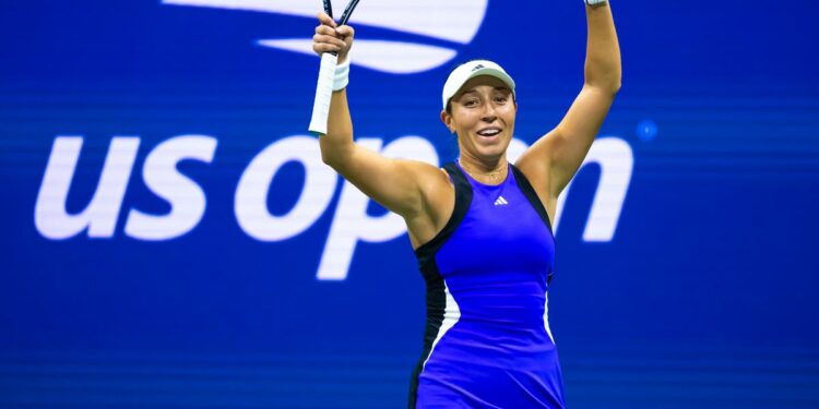 Jessica Pegula celebrates a win at the 2024 US Open, with her arms in the air, and wearing a blue dress.