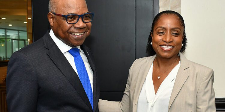 Edmund Bartlett (left), warmly greets Marie McKenzie