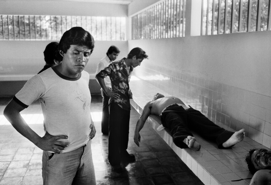 Salvadorans examine corpses in the city morgue in La Libertad, El Salvador, Aug. 10, 1984. The victims had been tortured and executed at close range, shot in the face, methods used by right-wing death squads during the civil war.