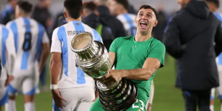 Emiliano Martinez of Argentina celebrates with the Copa America 2024 trophy after the FIFA World Cup 2026 Qualifier match between Argentina and Chile. Daniel Jayo/Getty Images