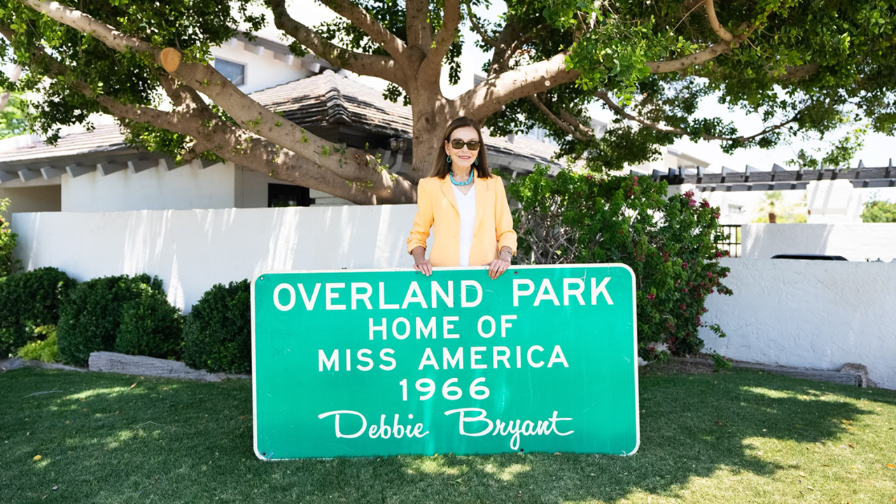 Debbie-Bryant-Miss-America-1966-with-City-of-OP-sign-Web.png