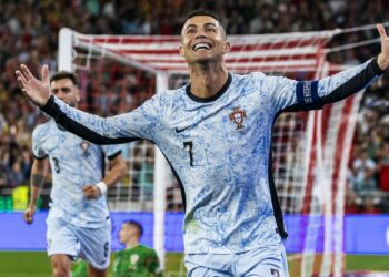 Cristiano Ronaldo celebrates his 900th career goal in a blue and white Portugal top.