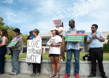 Supporters hold signs at a rally organized by the New Sanctuary Movement in support of Haitian immigrants outside of the National Constitution Center in Philadelphia on Thursday, Sept. 19, 2024.