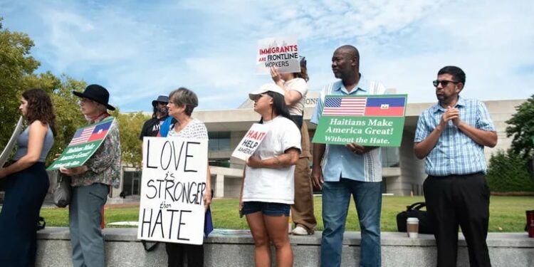Supporters hold signs at a rally organized by the New Sanctuary Movement in support of Haitian immigrants outside of the National Constitution Center in Philadelphia on Thursday, Sept. 19, 2024.