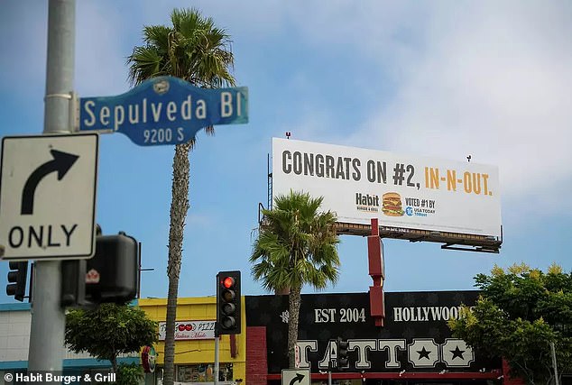 The particular advertisement sits above a tattoo parlor on Sepulveda Boulevard, directly across the street from an In-N-Out