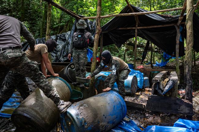 Honduran soldiers drench a coca processing laboratory with gasoline in order to set it on fire. (Fritz Pinnow)