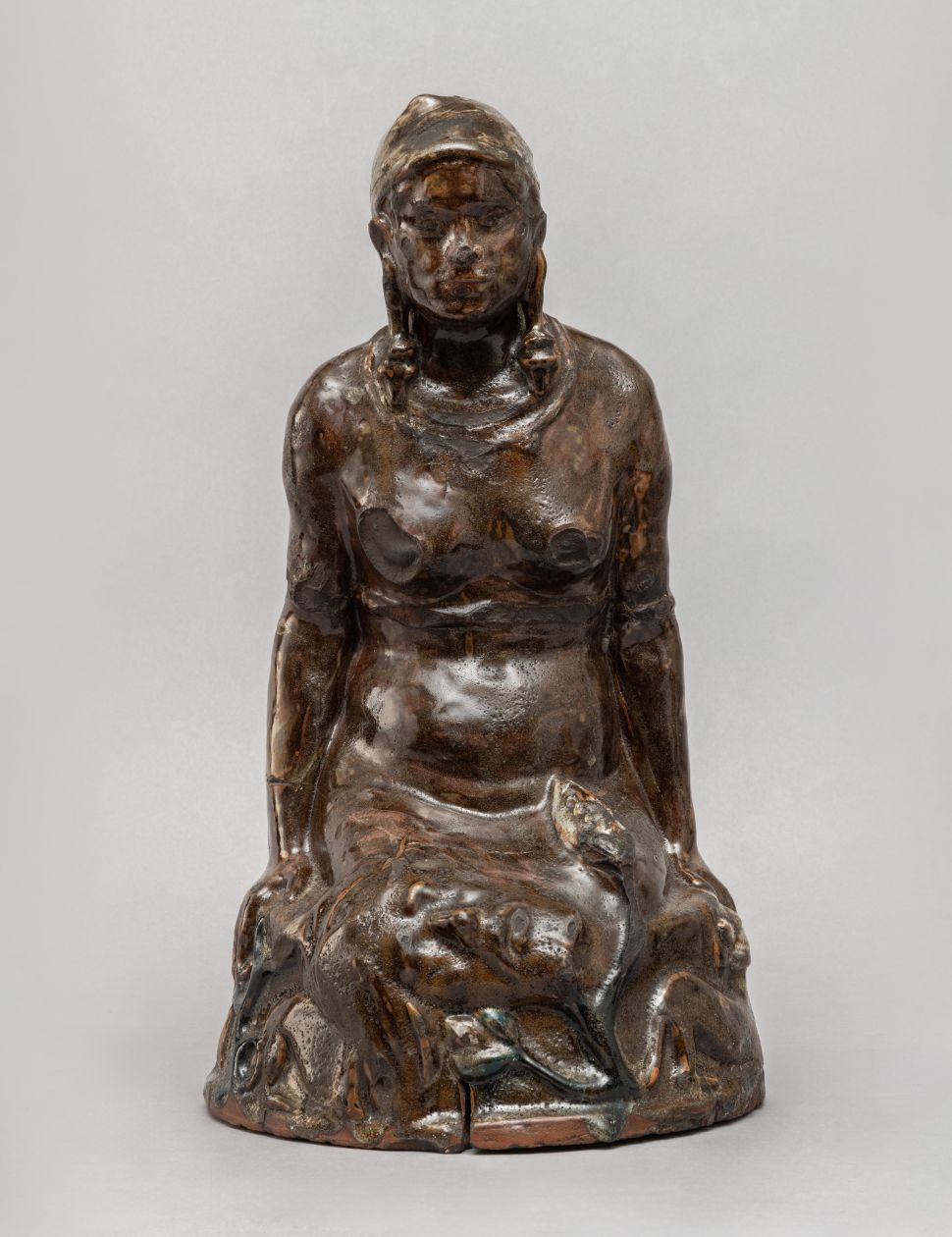 Image of a sculpture of a woman with a head on her laps. 