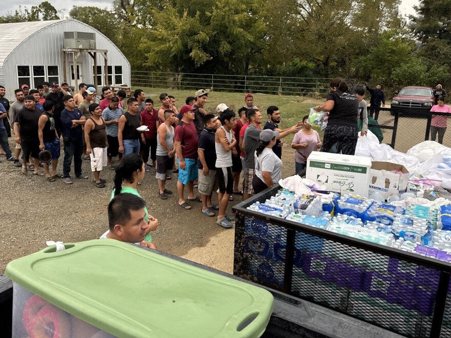 Sandra de Leon (right) hands out supplies to people from the community of Newport, Tenn. She and her husband, Ruben Aguilar, came to the U.S. from Guatemala decades ago and now manage 180 properties in the nearby town of Pigeon Forge.