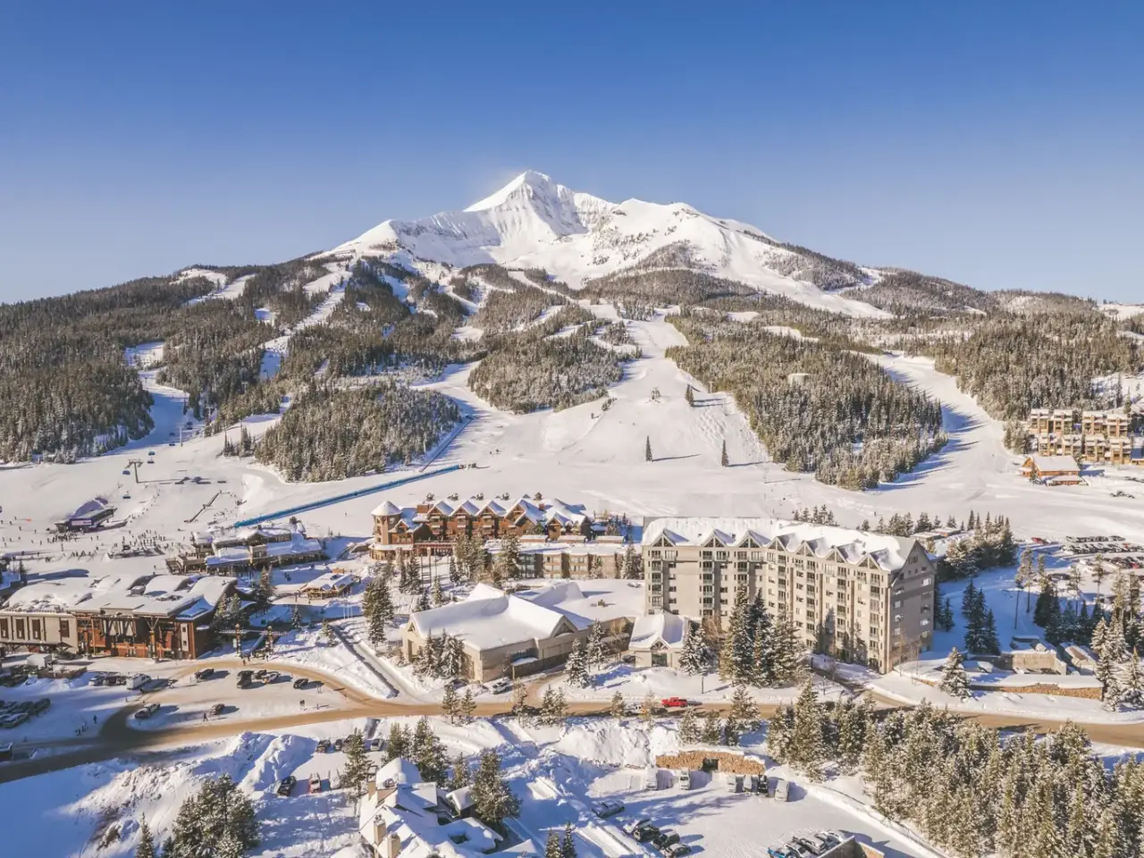 Aerial view of Big Sky Resort in Montana with snow-covered slopes and mountains.