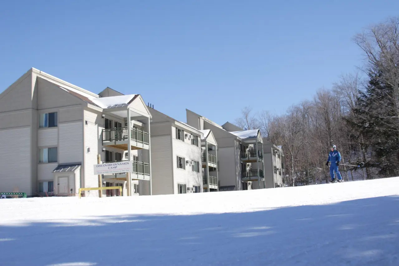 Ski slopeside accommodations at Smugglers’ Notch Resort with a skier in blue gear.