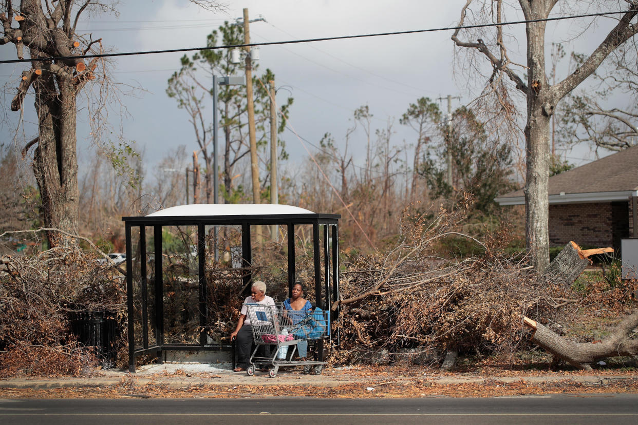 Mary Battles, left, and Shenike Bishop rest in a bus stop damaged by Hurricane Michael on Oct. 20, 2018 in Panama City, Florida. / Credit: Scott Olson / Getty Images