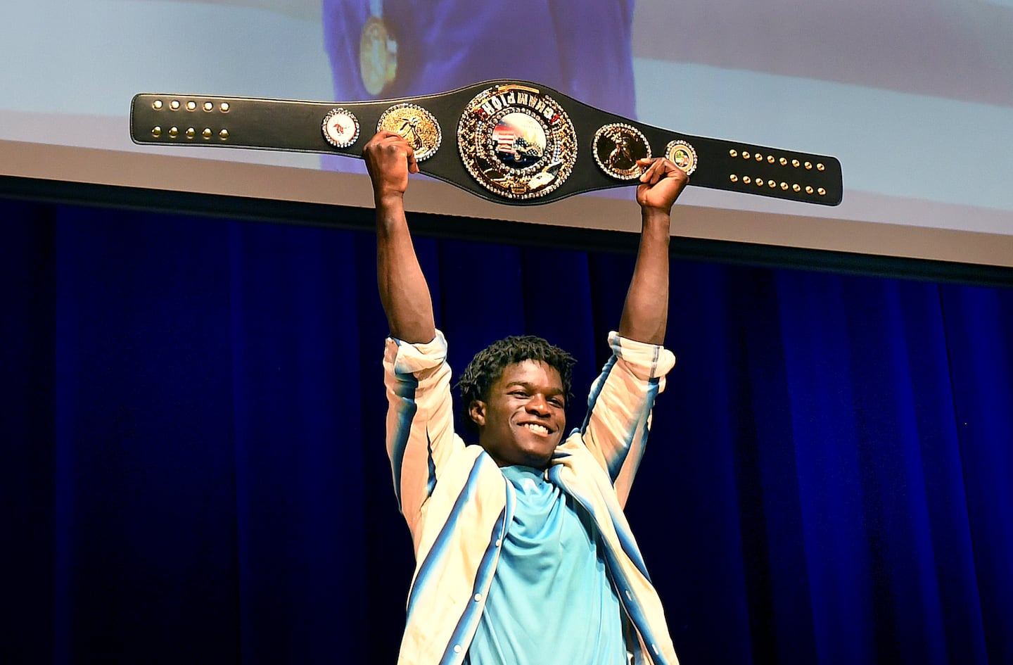 The Town of Stoughton held a celebration Sunday at Stoughton High School for hometown Olympian Frederick Richard, who won a bronze medal with Team USA in the 2024 Paris Olympics. Richard holds up a personalized champion belt with the Stoughton town seal on it.