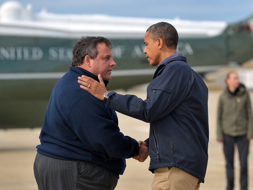 President Barack Obama (R) is greeted by New Jersey Governor Chris Christie upon arriving in Atlantic City, New Jersey, on October 31, 2012 to visit areas hit by Superstorm Sandy.