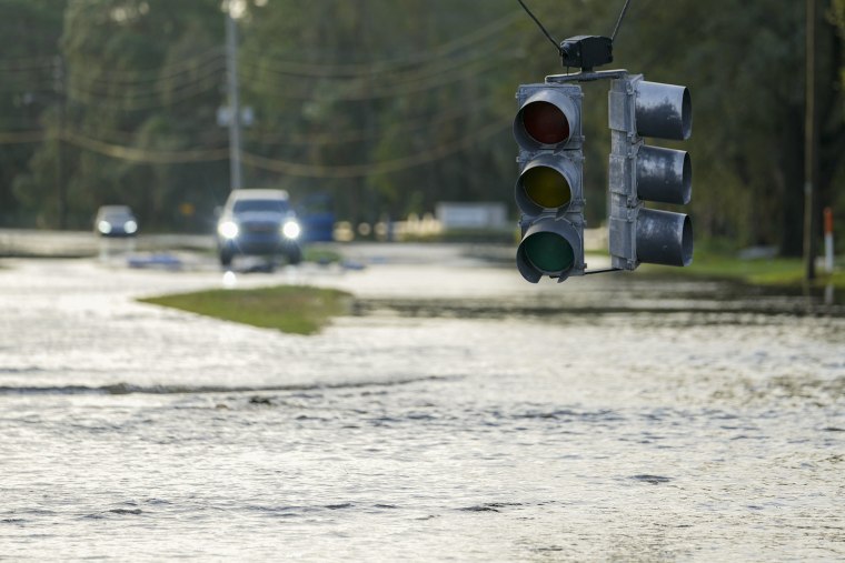 A non-functioning traffic light hangs low over floodwaters Thursday, Oct. 10, 2024, in Tampa, Fla. 