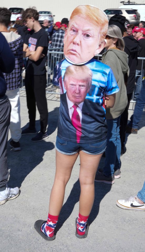 A trump fan at the rally is dressed head to toe in merchandise