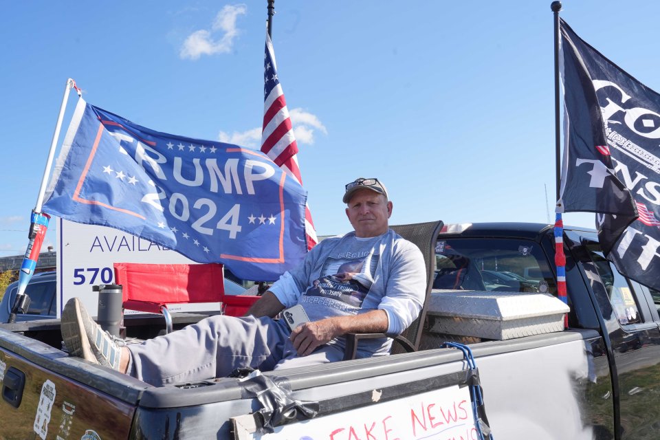 Parked on a verge at the entrance to Trump’s rally is Joe Granteed, 63, who flies a 'God, guns, Trump' flag from his truck, along with a sign reading 'No fake news zone'