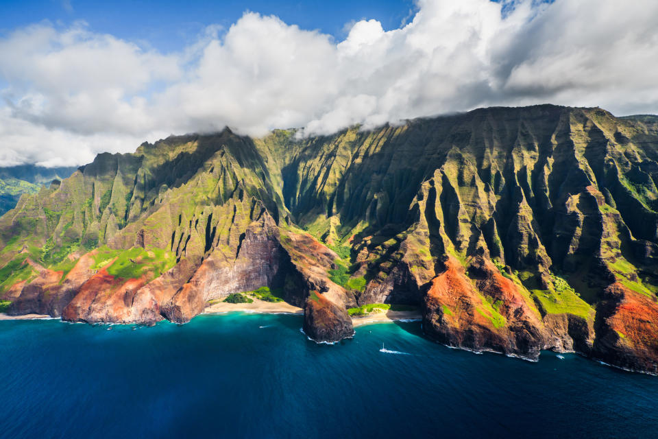 Stunning aerial view of the Na Pali Coast with lush, rugged cliffs and ocean waves. Ideal travel destination highlighting natural beauty