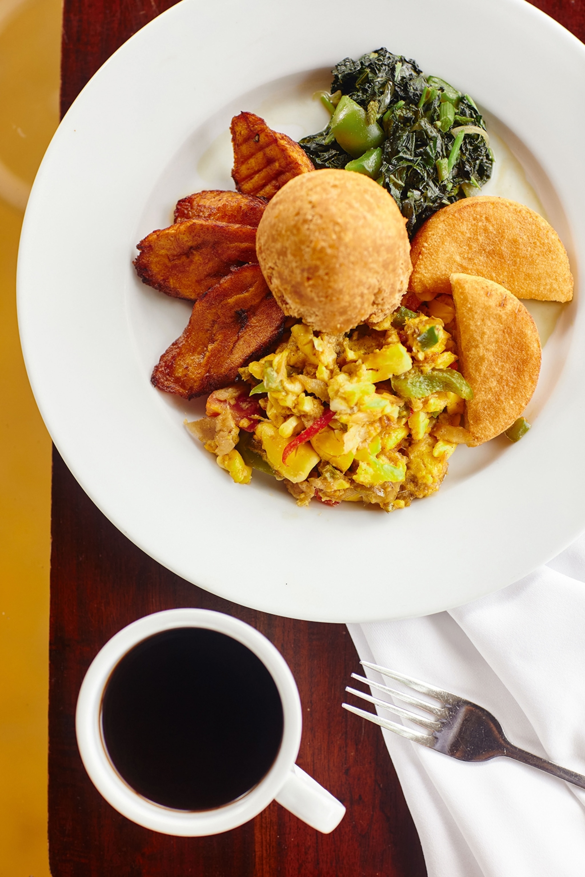 Plate of food with a fork and mug of coffee alongside