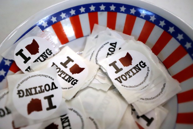 FILE – A bowl of voting stickers for early voters...