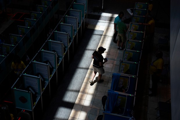 FILE – A voter walks to a voting machine during...