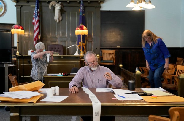 FILE – Esmeralda County Commissioner Ralph Keyes, center, works on...