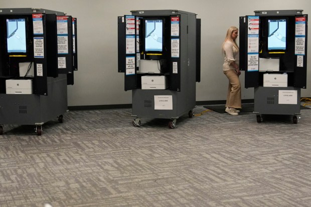 FILE – A person votes at a polling site for...