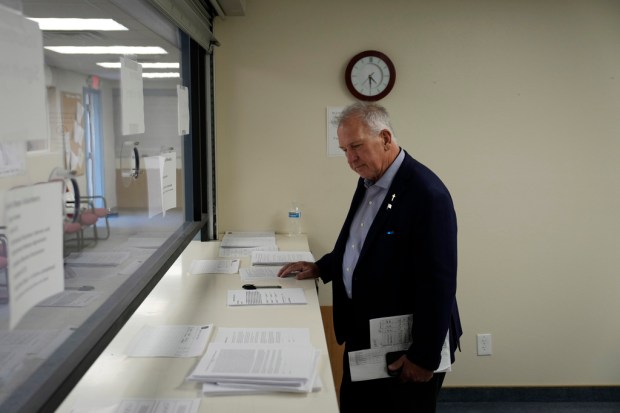 FILE – Then-interim Nye County Clerk Mark Kampf works in...