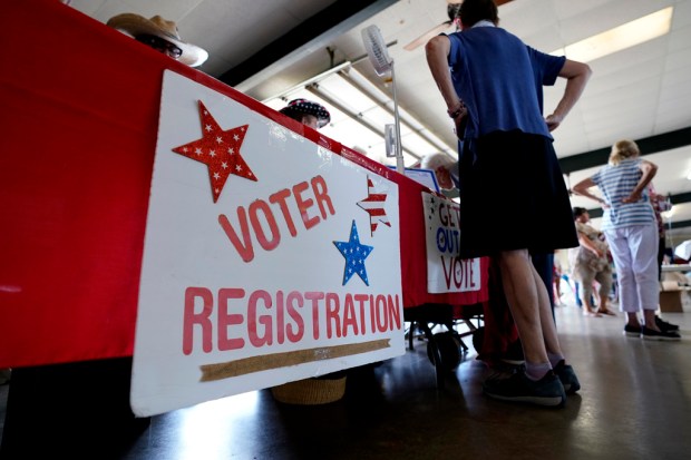 FILE – A voter registration table is seen at a...