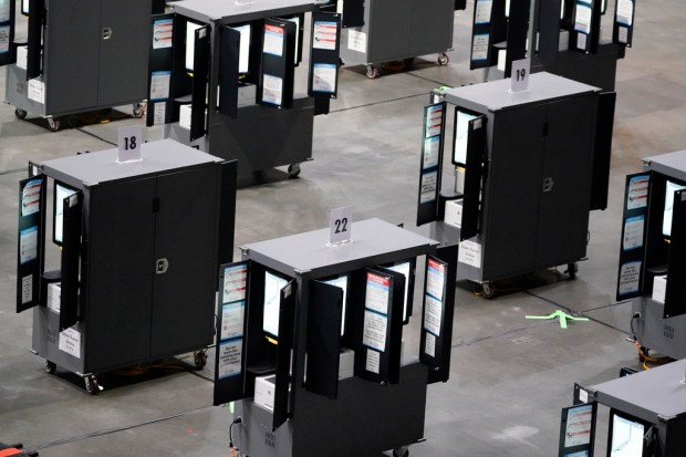 FILE – Voting machines fill the floor for early voting...