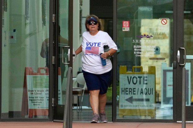 A voter leaves Surprise City Hall after voting on the...