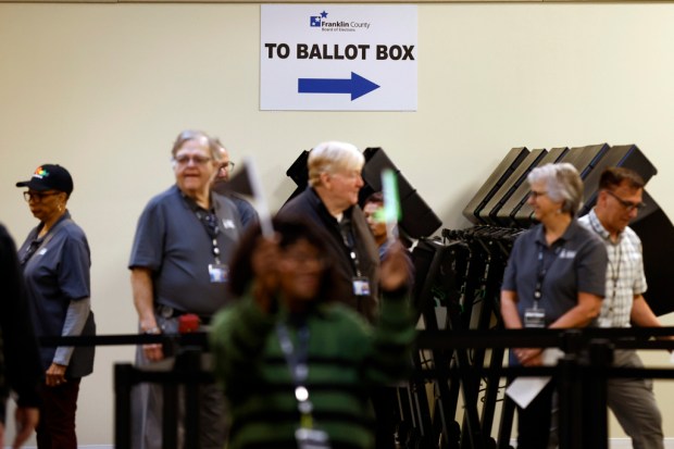 Poll workers wait to escort voters to the polling booths...