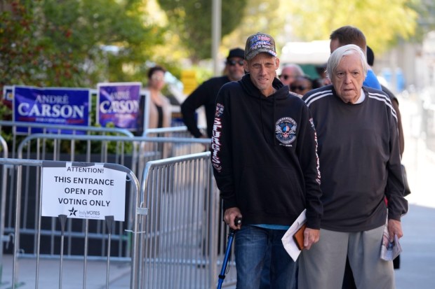 Voters wait in line for in-person absentee voting at the...