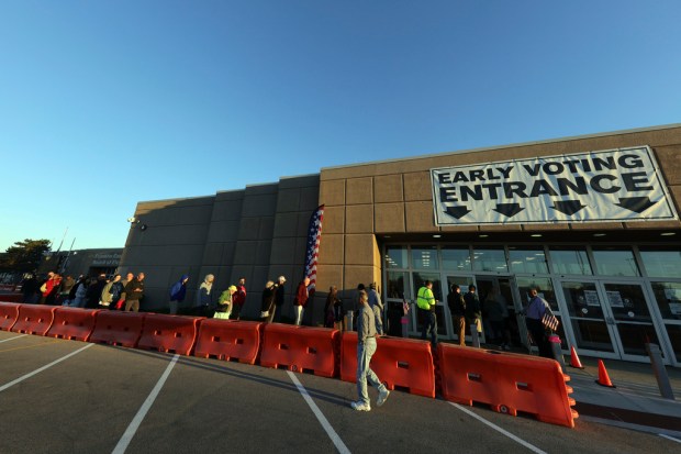 Voters enter the early voting center for the first day...