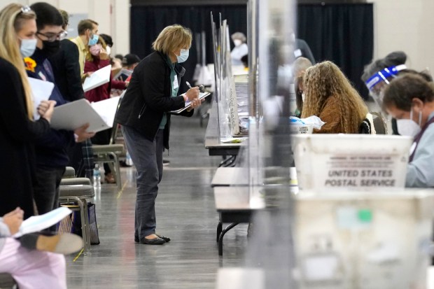 FILE – Recount observers watch ballots during a Milwaukee hand...