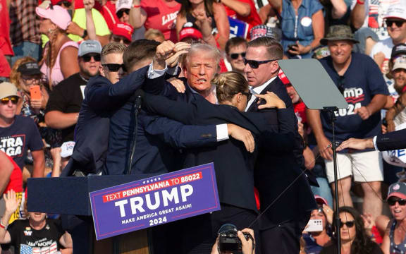 Republican candidate Donald Trump is seen with what appears to be blood on his face surrounded by secret service agents as he is taken off the stage at a campaign event at Butler Farm Show Inc. in Butler, Pennsylvania, July 13, 2024. Republican candidate Donald Trump was evacuated from the stage at today's rally after what sounded like shots rang out at the event in Pennsylvania, according to AFP.
The former US president was seen with blood on his right ear as he was surrounded by security agents, who hustled him off the stage as he pumped his first to the crowd.
Trump was bundled into an SUV and driven away. (Photo by Rebecca DROKE / AFP)