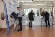 People participate in early voting at the George L. Allen Sr. Courts Building on Tuesday,...