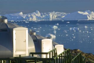 Three aluminum igloos with windows designed to see the northern lights at the shore of the Ilulissat Icefjord